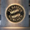 Black metal Bayern München logo wall art with golden accents.