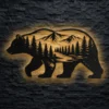 A large rustic bear mountain silhouette metal art with LED backlighting on a dark brick wall.