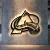 Black metal Colorado Avalanche logo wall art with bright LED backlighting.