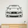 Black outline metal art of a Ford Mustang GT front view on a white wall.