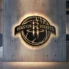 Black metal Houston Rockets logo wall art with bright LED backlight.