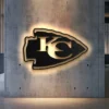 Black metal Kansas City Chiefs arrowhead logo wall art with LED backlighting.