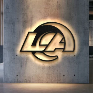 Black metal Los Angeles Rams logo wall art with warm LED glow on concrete wall.