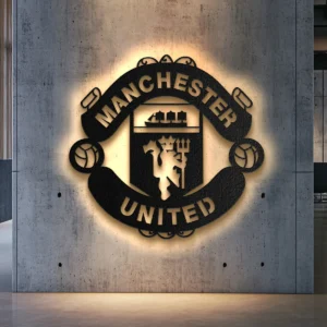 Black metal Manchester United logo wall art with bright LED backlighting on a concrete wall.