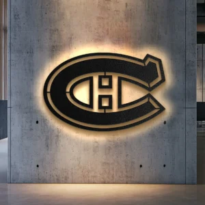 Black metal Montreal Canadiens logo wall art with warm LED backlight on a concrete wall.