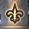 Black metal New Orleans Saints fleur-de-lis logo wall art with bright backlighting.