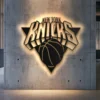 Black metal New York Knicks logo wall art with bright LED backlighting.
