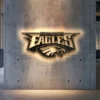 Black metal Philadelphia Eagles logo wall art with warm LED backlight.