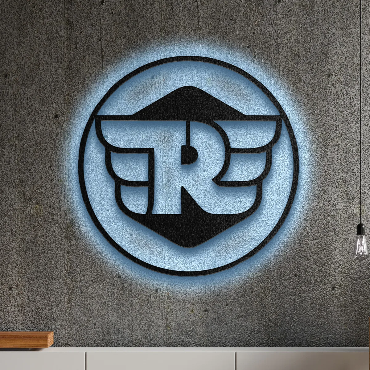 Black metal Royal Enfield logo wall art with blue LED backlight on a concrete wall
