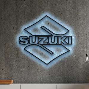 Black metal Suzuki logo wall art with blue LED glow on a concrete wall.