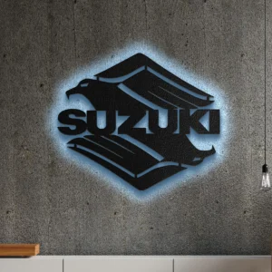 Black metal Suzuki logo wall art with blue LED backlight on concrete wall.