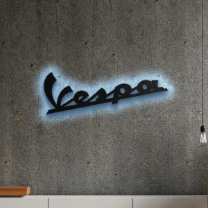 Black metal Vespa logo wall art with blue LED backlight on a concrete wall.