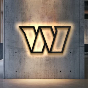Black metal Washington team logo wall art with warm LED backlight on a concrete wall.