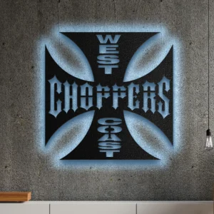 West Coast Choppers Iron Cross metal logo with blue LED backlighting on a concrete wall.