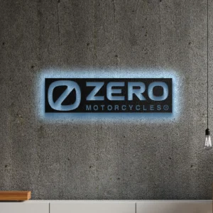 Black metal Zero Motorcycles logo wall art with blue LED backlighting on a concrete wall.
